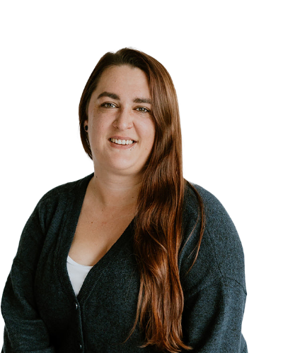 A woman with long brown hair wearing a dark sweater and white top, smiling at the camera against a plain white background.