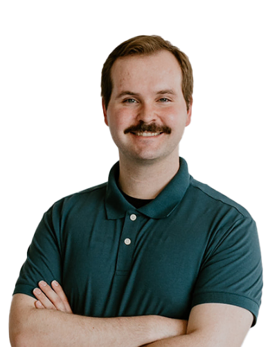 Man with a mustache wearing a teal polo shirt stands with arms crossed and smiles at the camera against a plain white background.