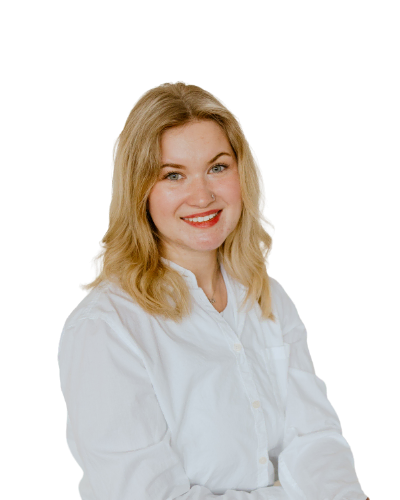 A woman with blonde hair wearing a white shirt smiles at the camera against a plain white background.
